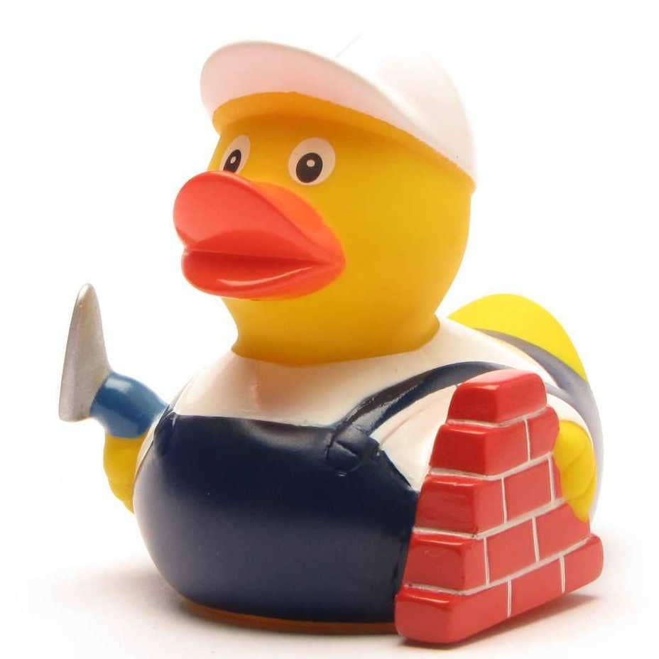 Pato constructor con casco y herramienta de albañilería