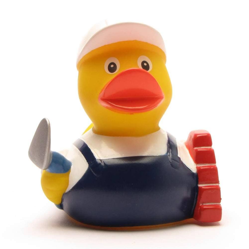 Pato de goma albañil con paleta y muro de ladrillos