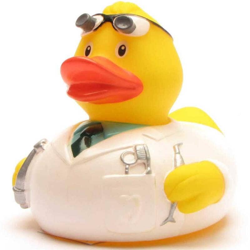 Pato de goma dentista con bata blanca e instrumental dental